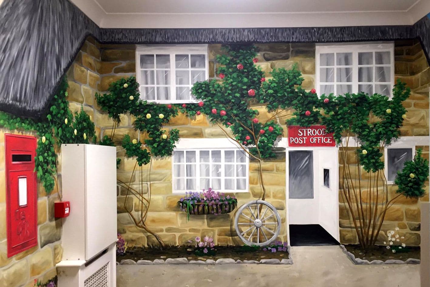 A wall mural of the old Strood Post Office, with roses around the door